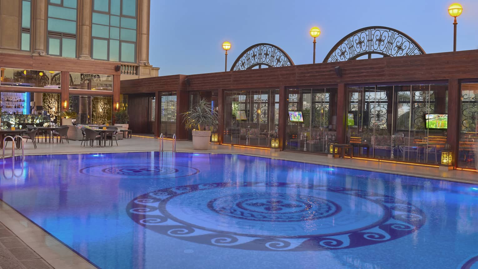 Outdoor pool illuminated under moonlit sky