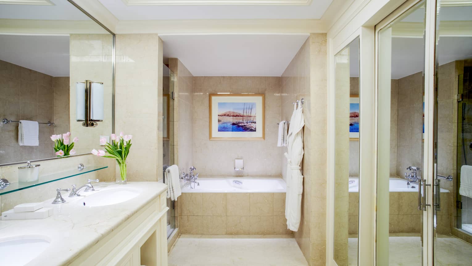 Premium Executive Suite bathroom with double vanity, full-width mirror, in-ground soaking tub, mirrored sliding doors to closet