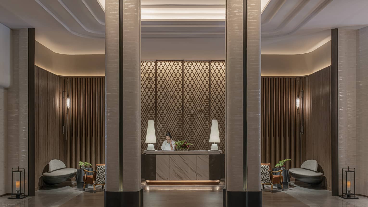 Spa lobby with floor-to-ceiling columns, lighted wall sconces and reception desk