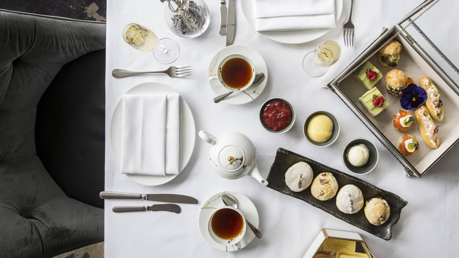 Aerial view of elegant afternoon tea display, complete with finger foods and condiments