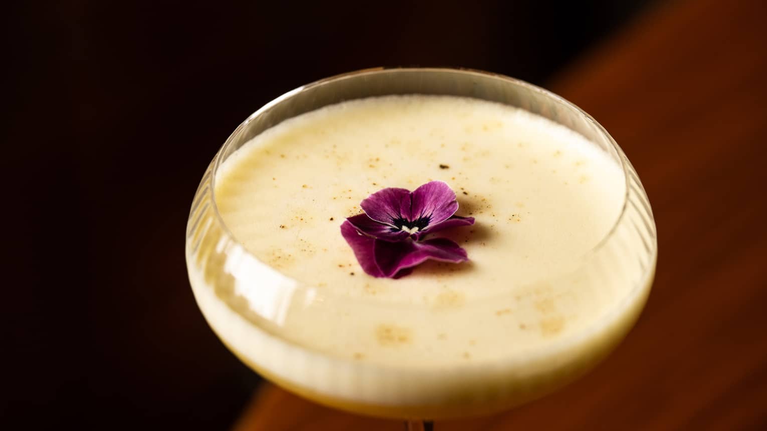 Cocktail with purple flower garnish