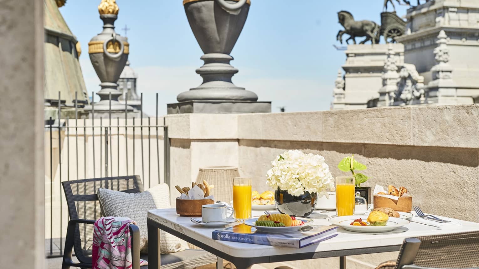Dining table with two chairs on private terrace, with view of Madrid statue