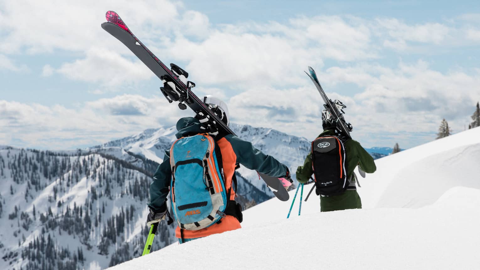 Two people in ski gear walking along a ski trail