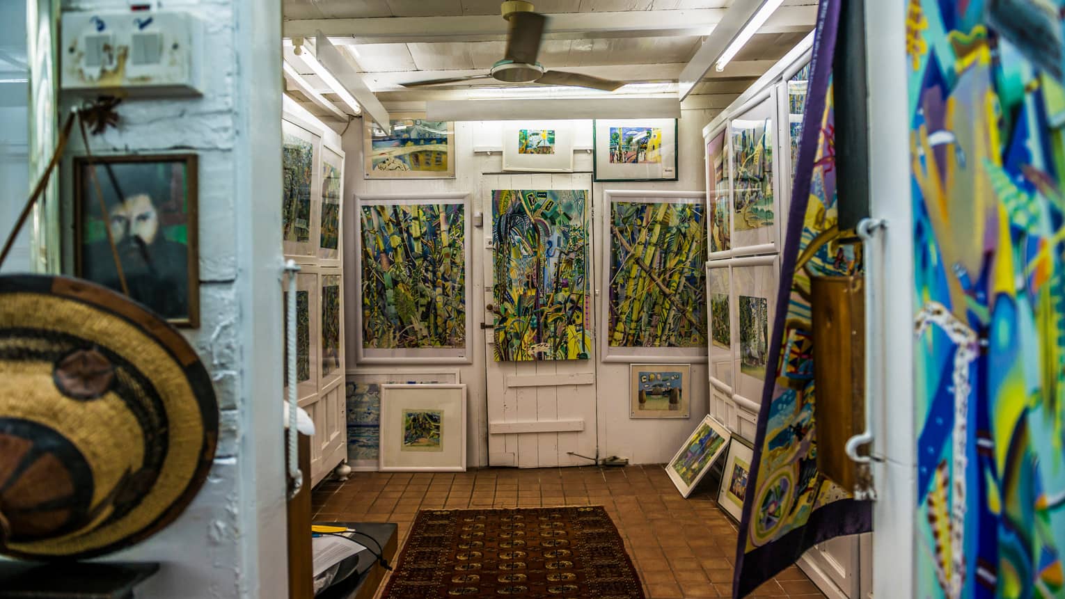 Interior of Michael Adams Gallery with colourful paintings on white walls 