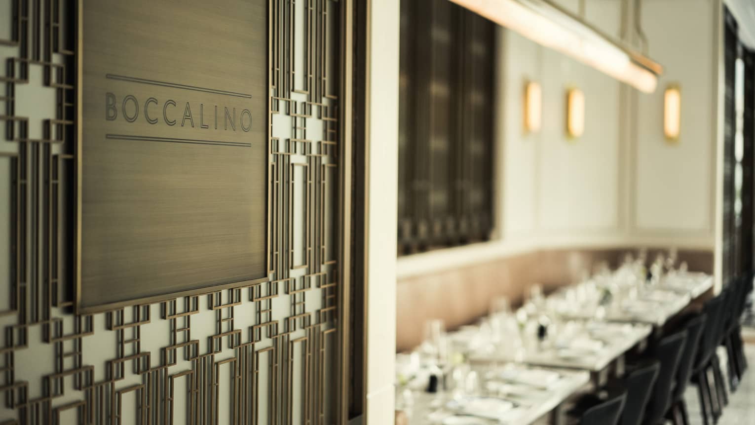 Boccalino Restaurant sign on wood wall, dining room in background