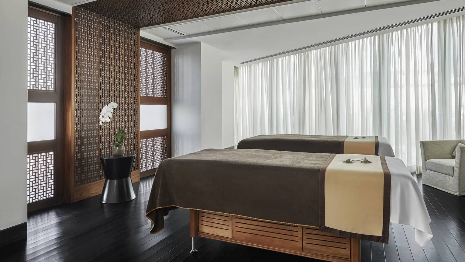 Pearl Spa side by side couples massage beds in treatment room with wood accent walls