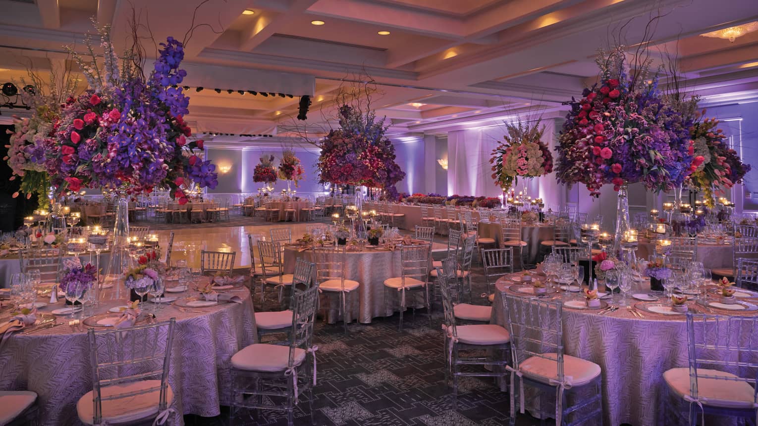 Royal Poinciana candle-lit ballroom with purple lights, tropical flower-filled banquet tables
