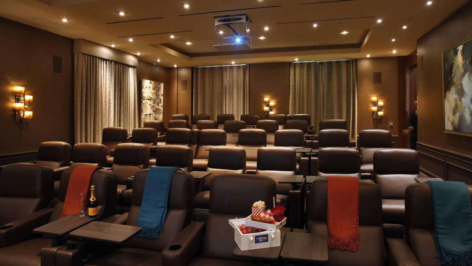 A small movie theatre with a box of snacks in the front row.