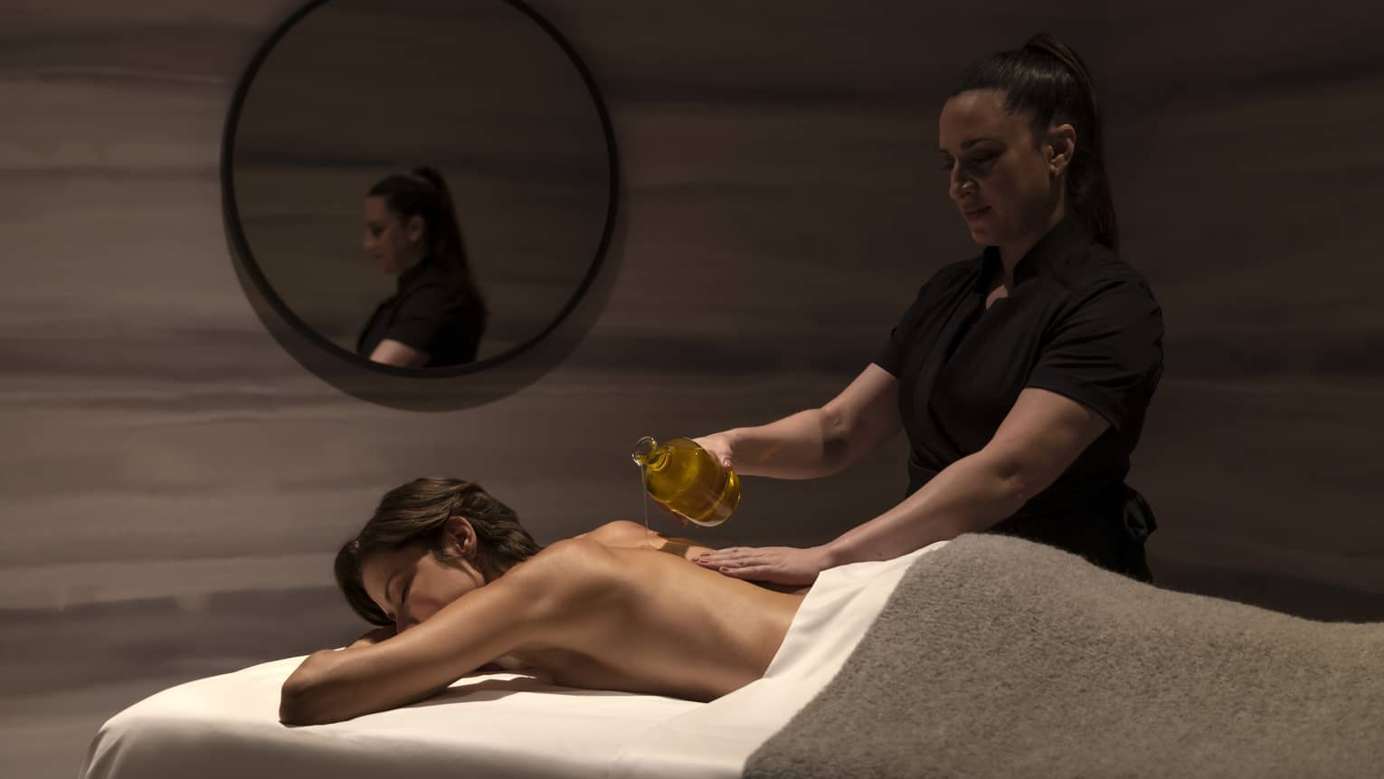 A woman getting a massage in a dimly lit room.