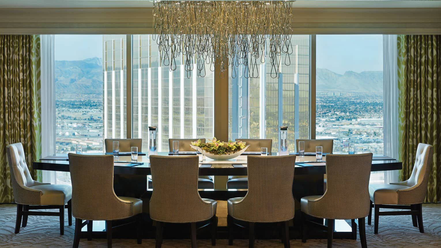 Private dining table under modern artistic chandelier by floor-to-ceiling windows 