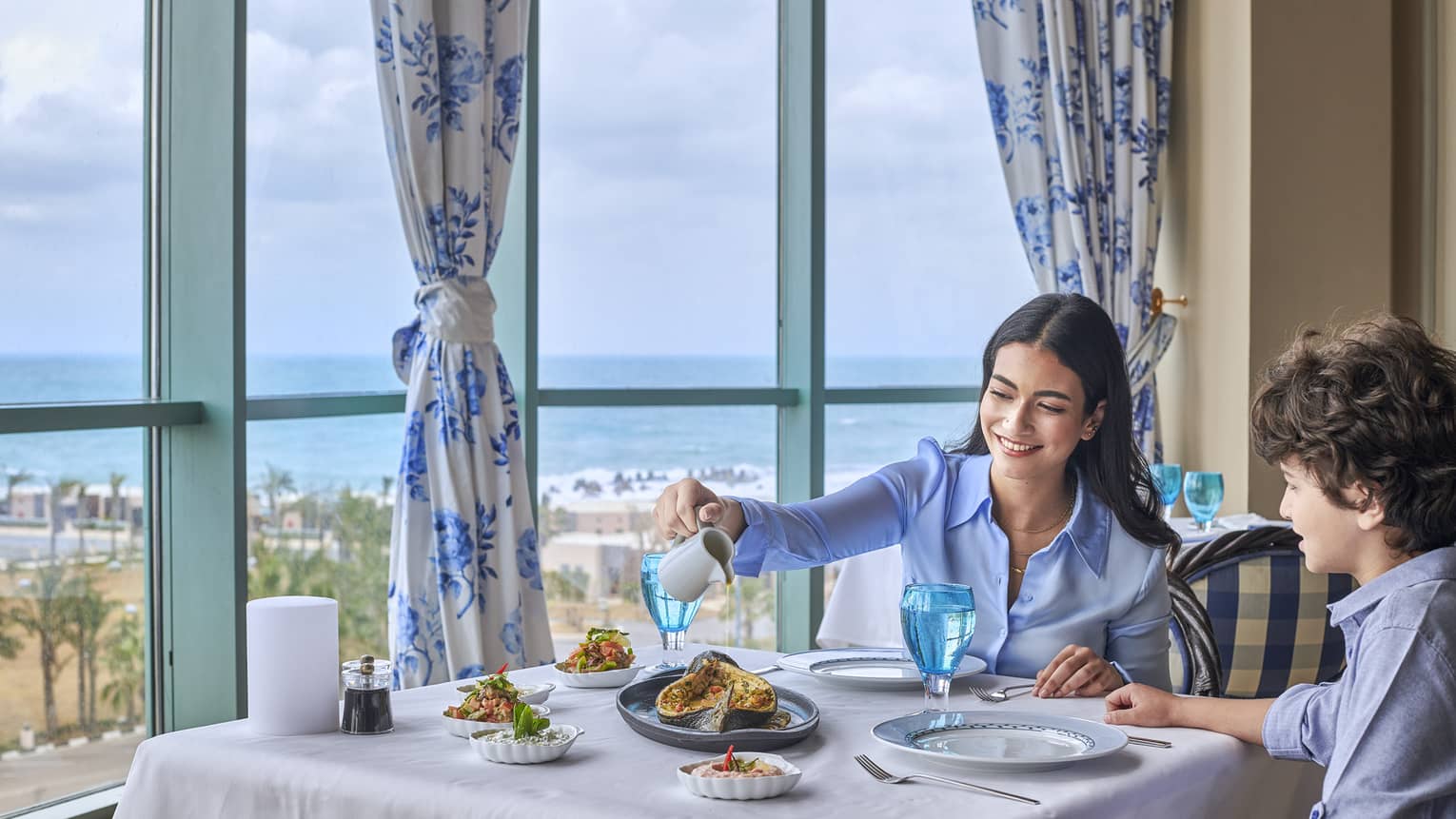 Mother and son enjoy fine dining at Kala Restaurant with views of the Mediterranean Sea