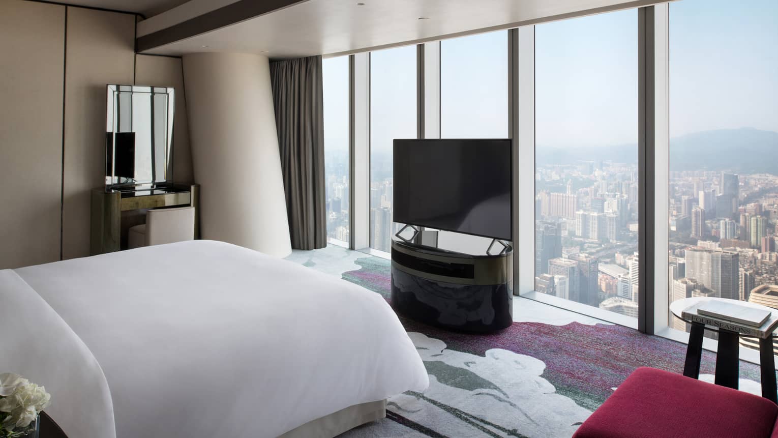 Deluxe King Suite City View Room with red accents and floor-to-ceiling windows