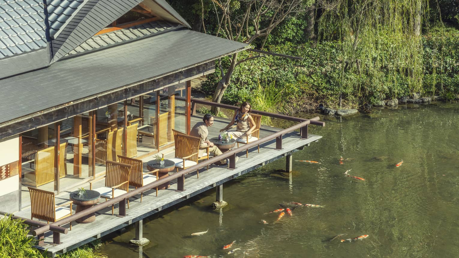 Couple enjoys tea on FUJU's terrace overlooking the koi pond
