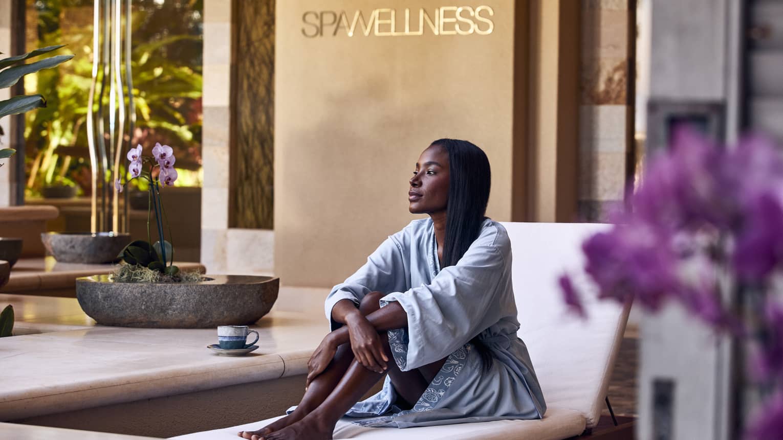 A woman sitting on a lounge chair in a spa.
