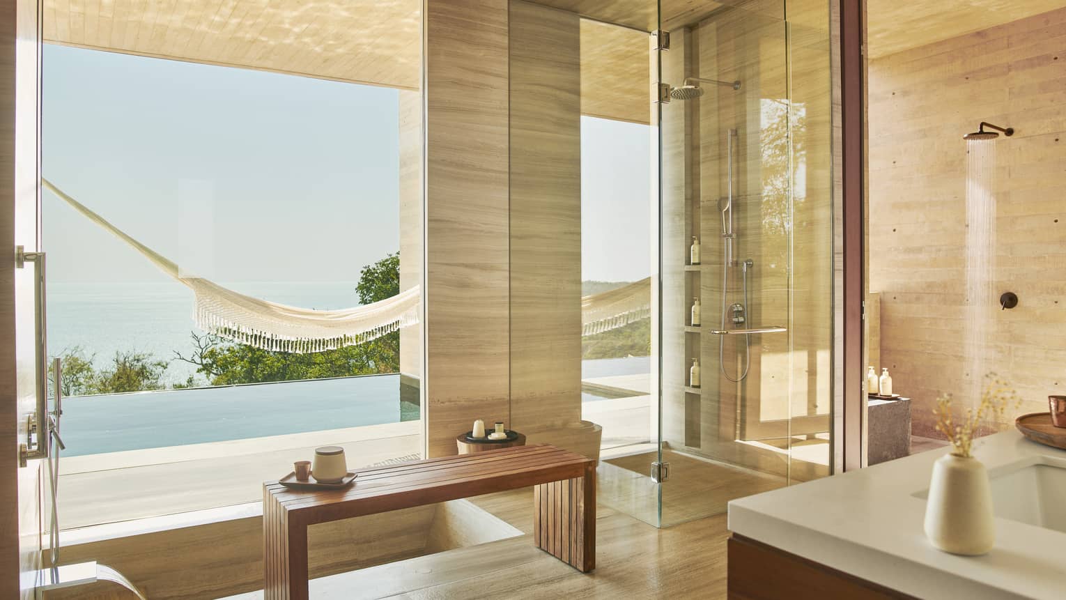 Indoor-outdoor, modern bathroom with infinity pool and ocean view