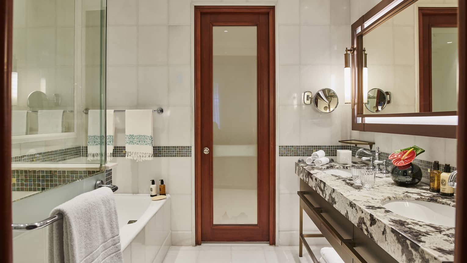 Luxurious bathroom with glass-enclosed shower, soaking tub, full marble vanity and brown mirror and door