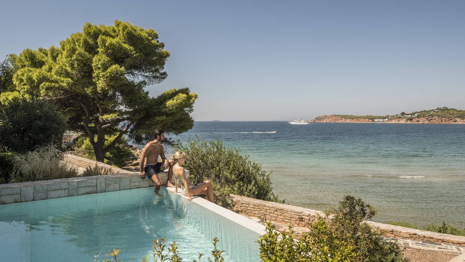 Couple relaxes in the Bungalow Suite Pool overlooking the Mediterranean Sea