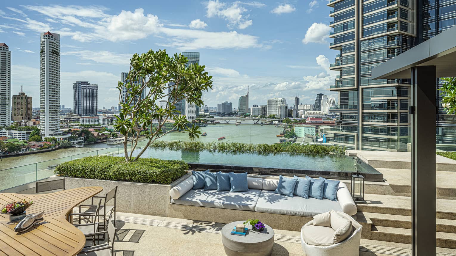 Private outdoor terrace with built-in sofa and pool with Bangkok river view