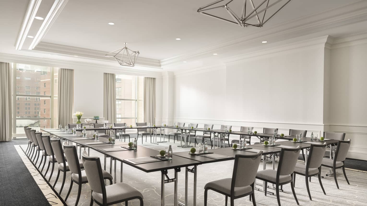 White conference room with dark tables in boardroom-style seating