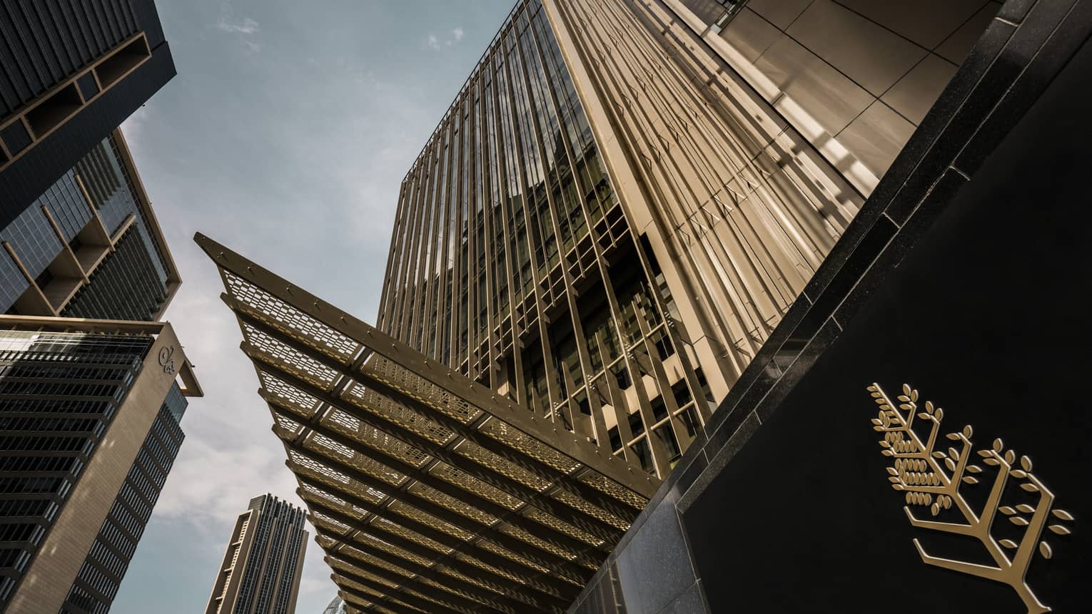 Looking up at high rise Dubai International Financial Centre hotel past gold Four Seasons logo