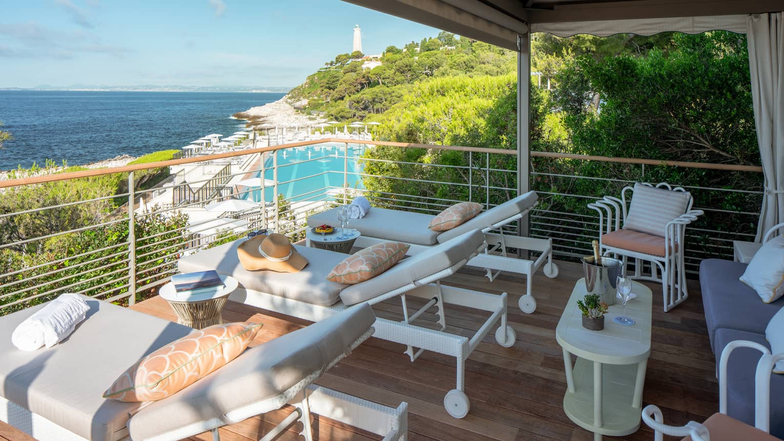 Club Dauphin private cabana terrace with lounge chairs, peach pillows, overlooking pool, Mediterranean