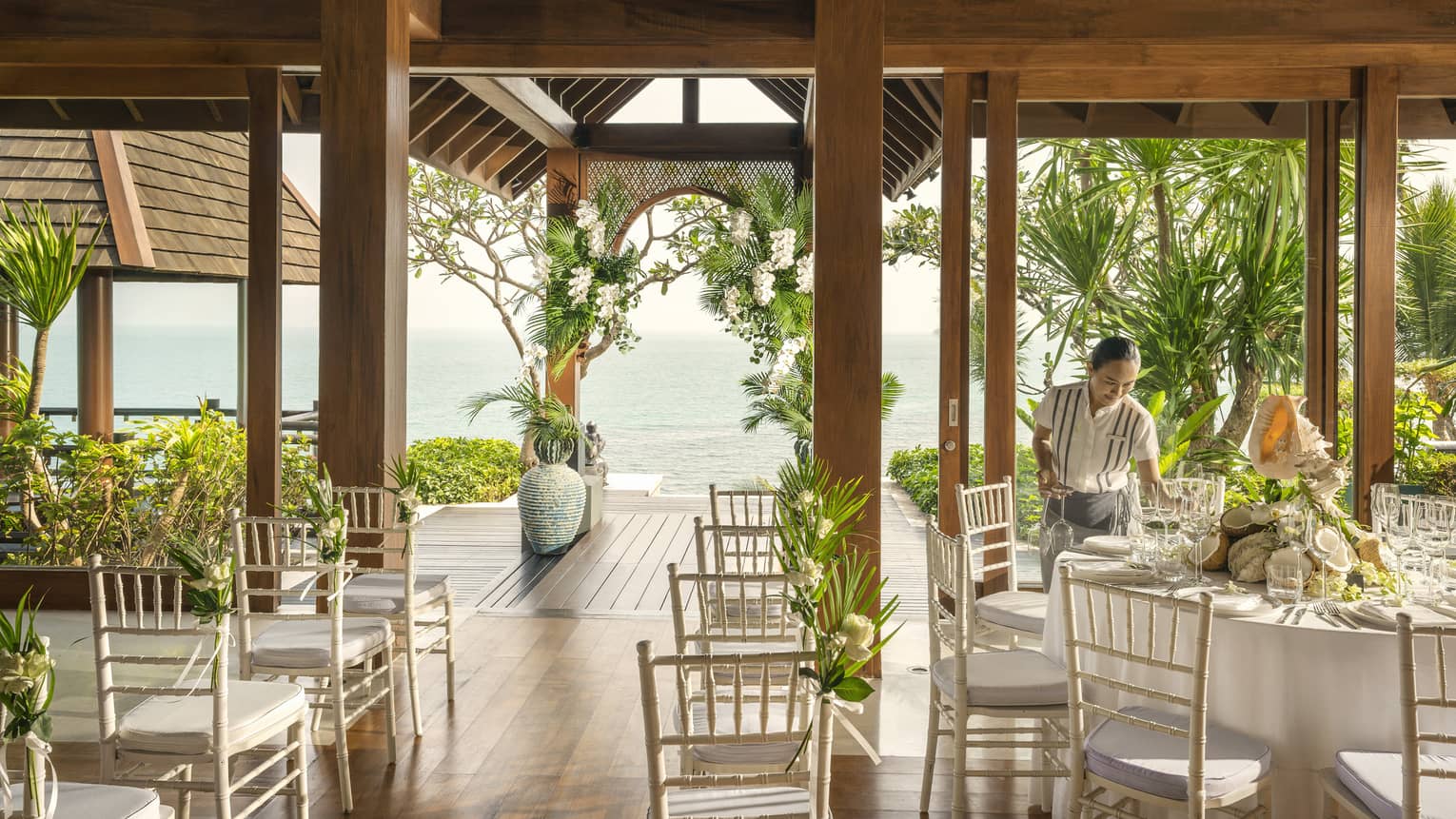 Wedding specialist sets banquet table at open-air wedding venue