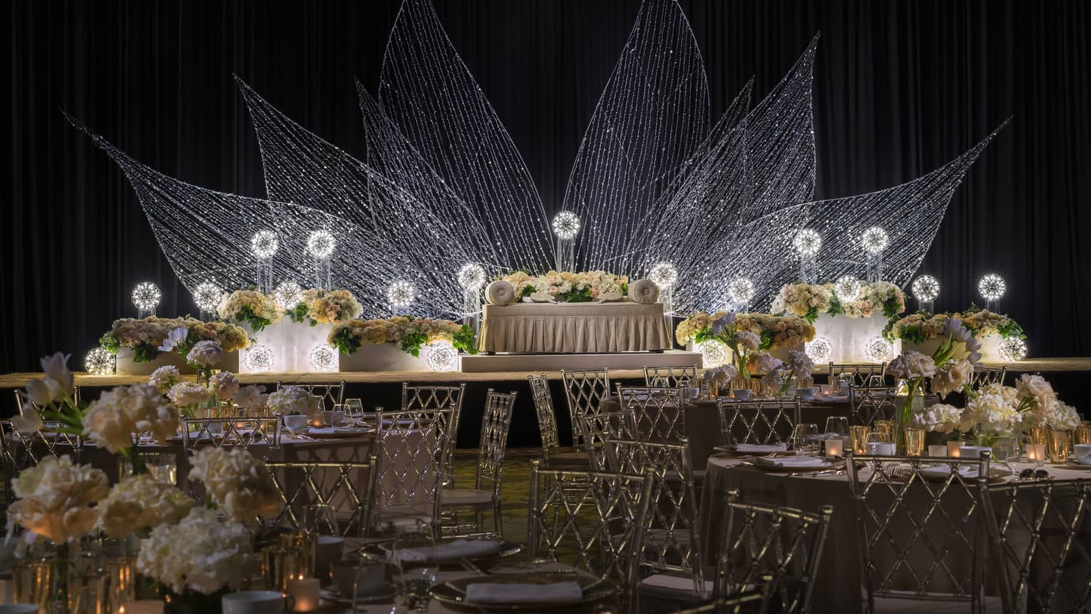 Malay wedding with banquet tables, white loveseat in front of flower light display