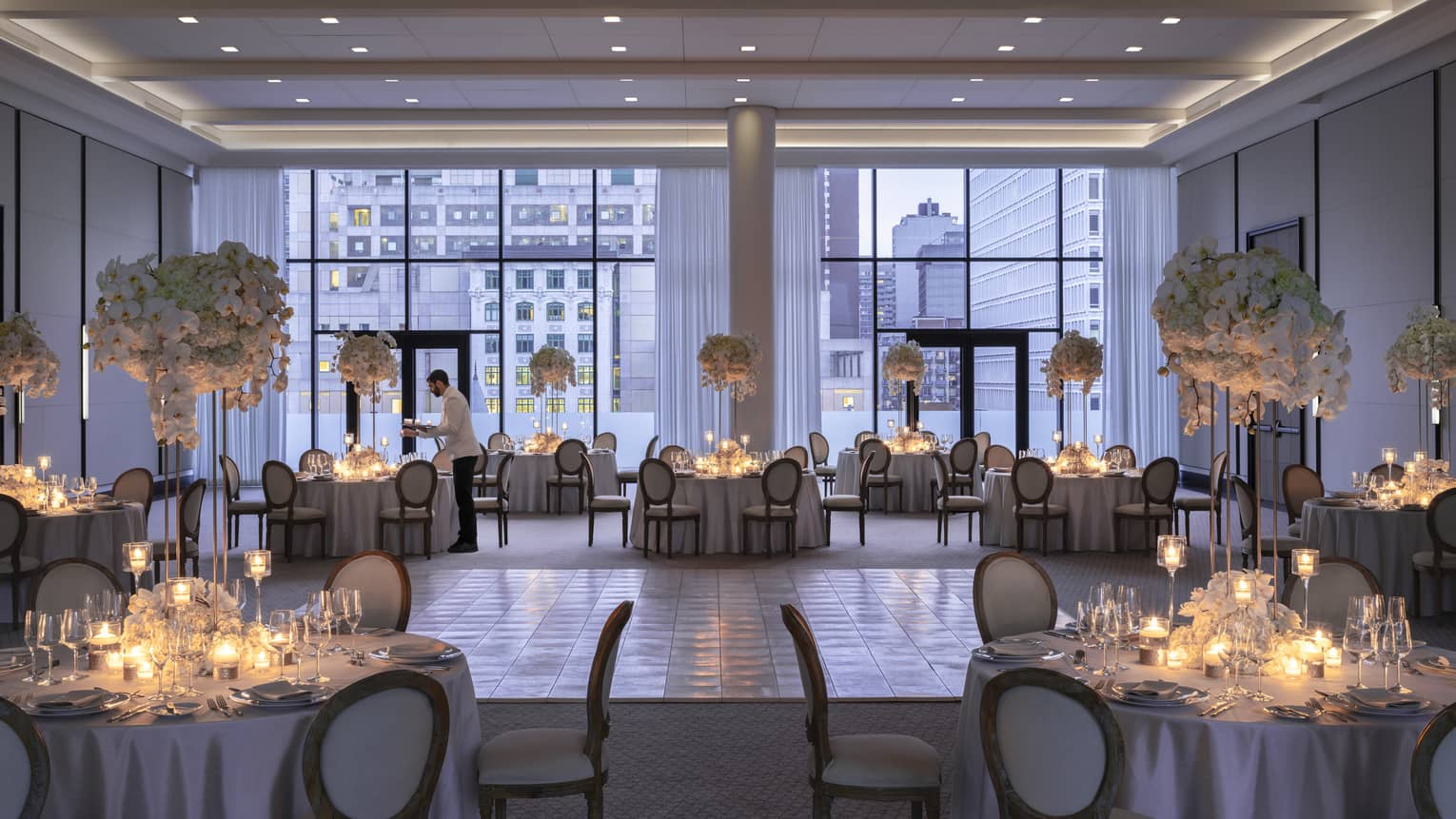 Four Seasons staff sets round table with candles in Palais des Possibles Ballroom