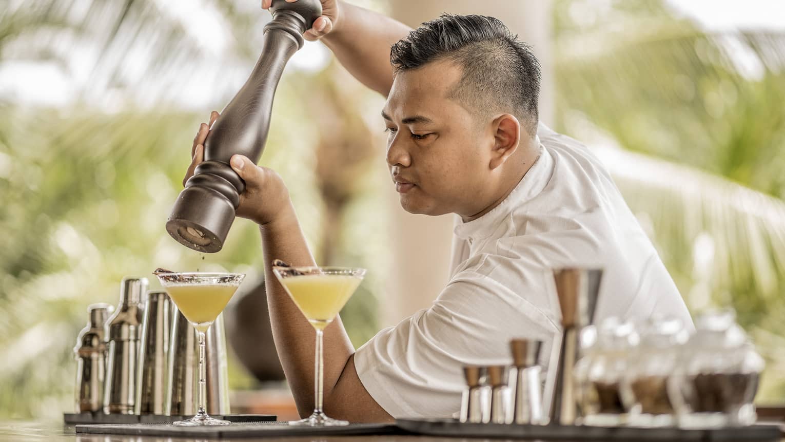 A bartender garnishing a drink with spices in Bali