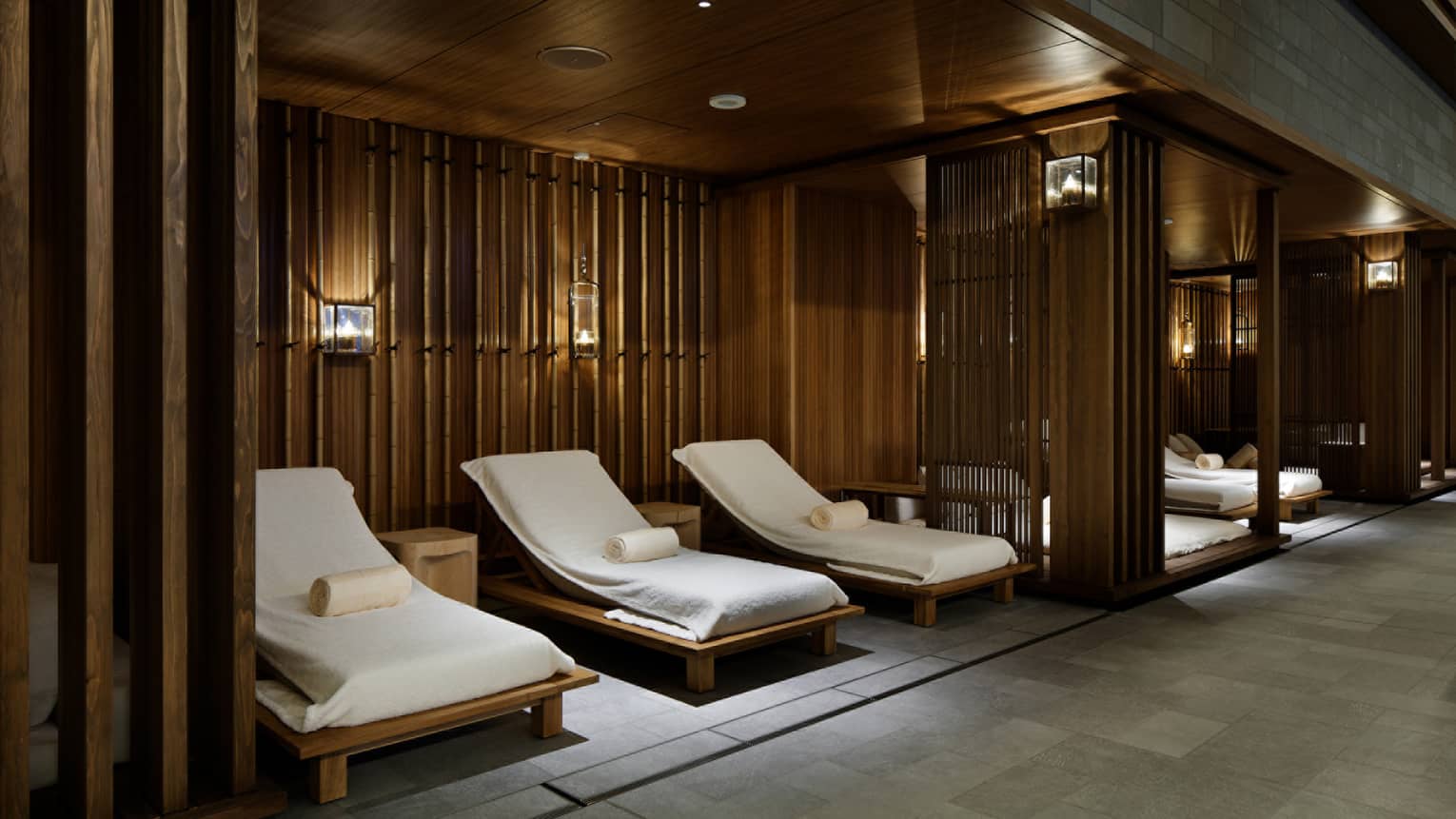Lounge chairs with white towels under wood walls in spa
