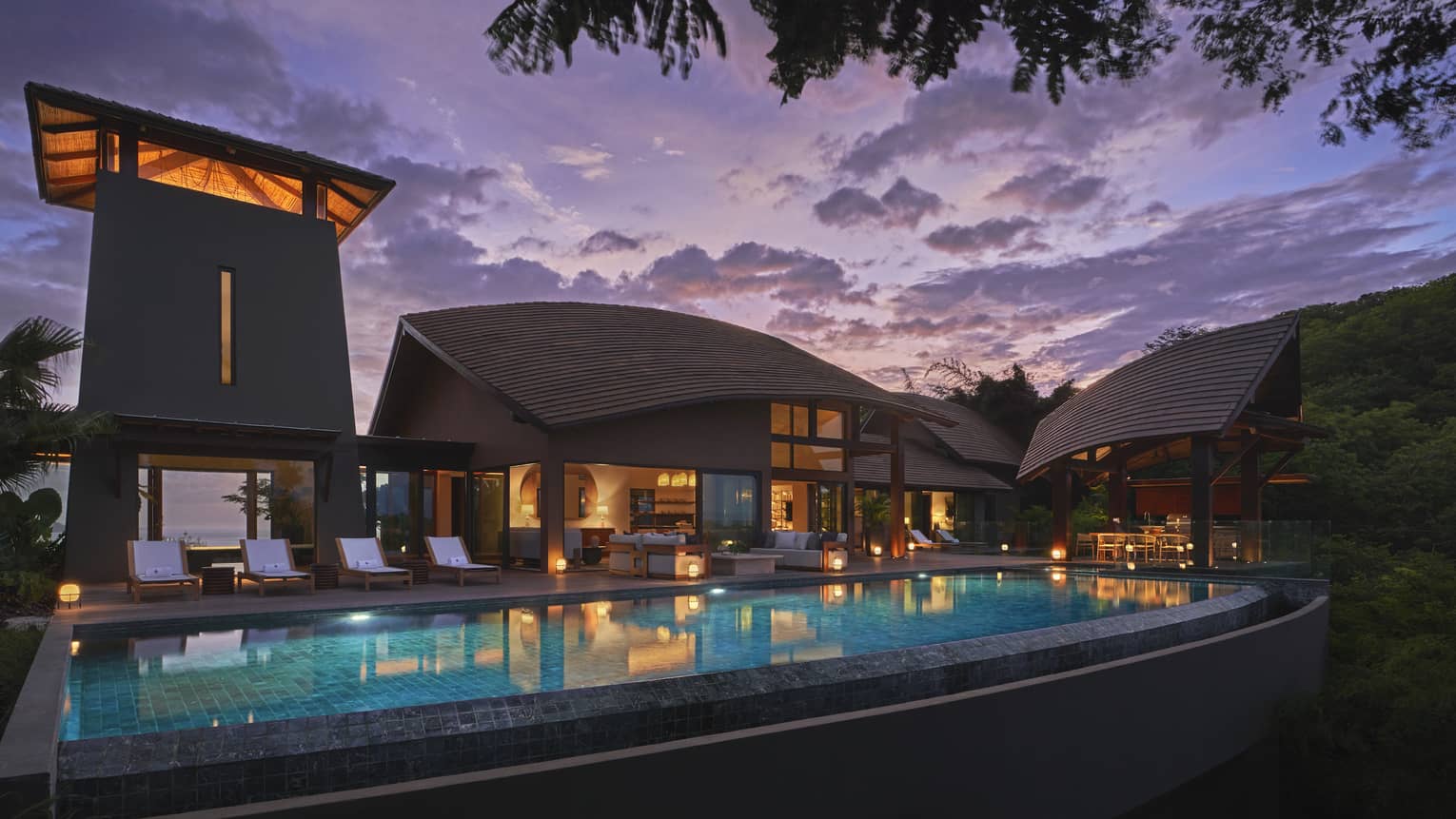 Private villa and pool illuminated at night