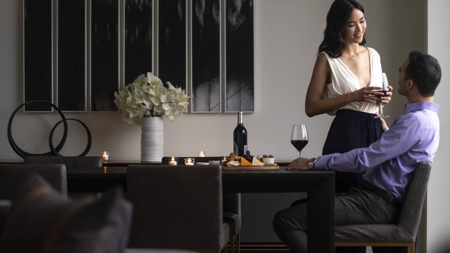 Man and woman drink wine at dining table