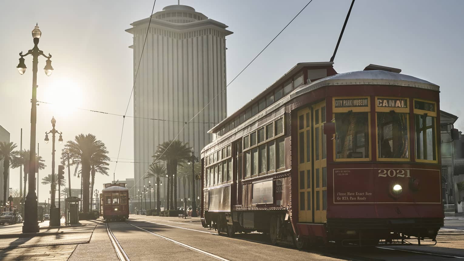 A new orleans train on a brightly lit road with Four Seasons New Orleans in the background