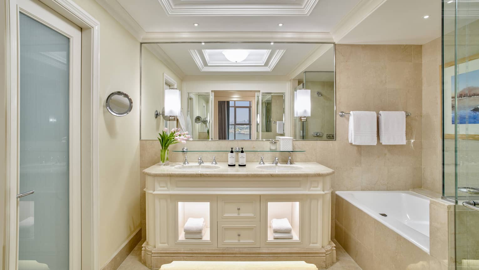 Guest bathroom with double vanity, full-width mirror, large soaking tub and glass shower