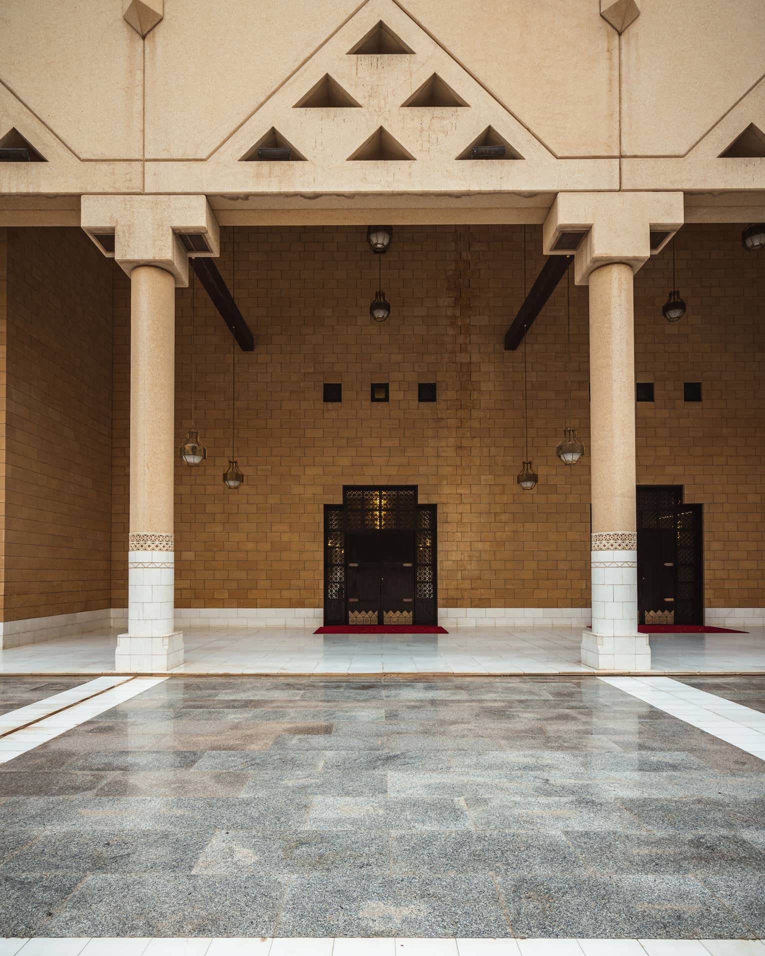 A brown stone wall with grey tile flooring.