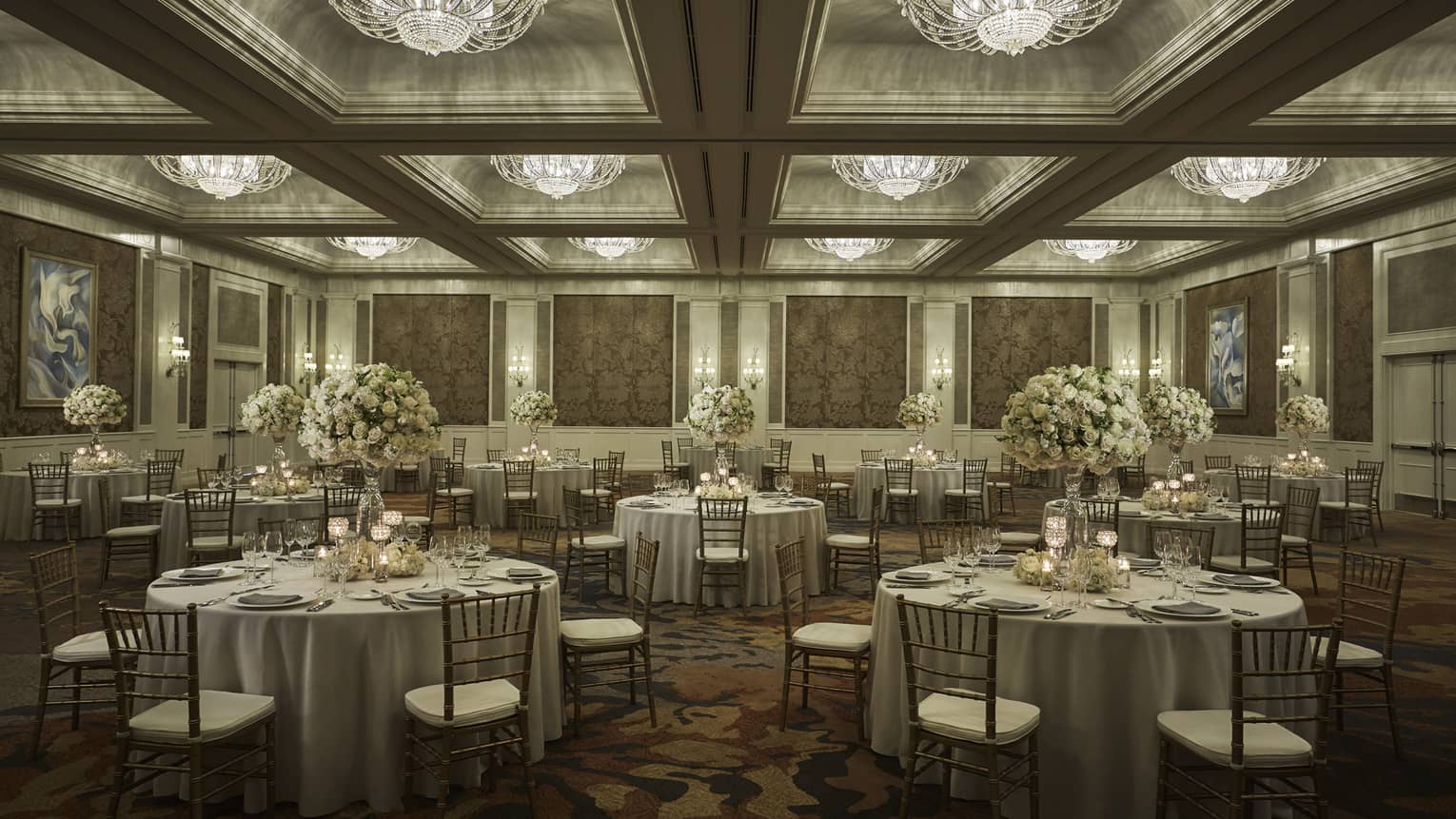 Round tables under crystal chandeliers in elegant Ocean Ballroom event space 