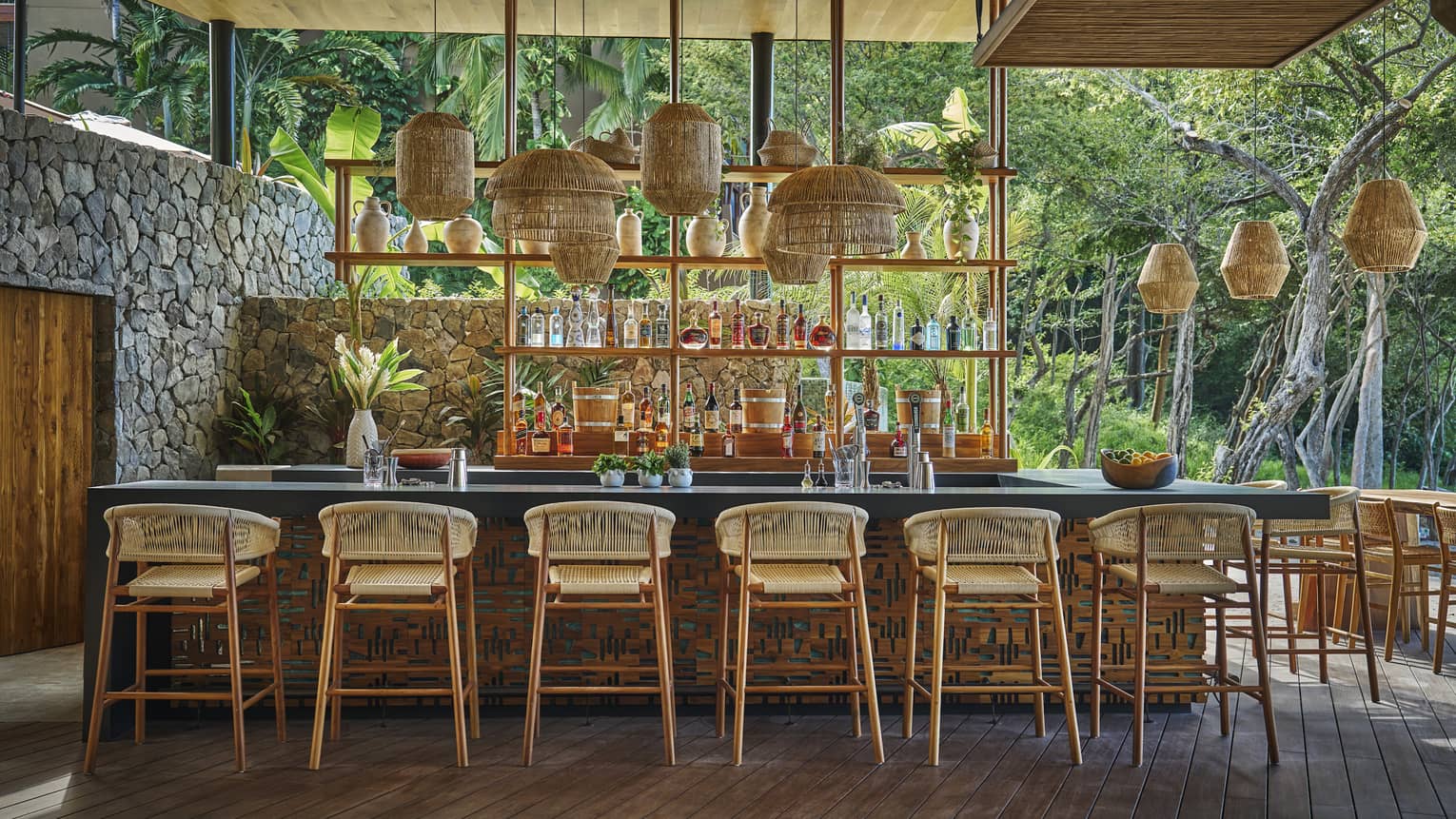 Interior bar of restaurant with rattan stools and a wall of beverages