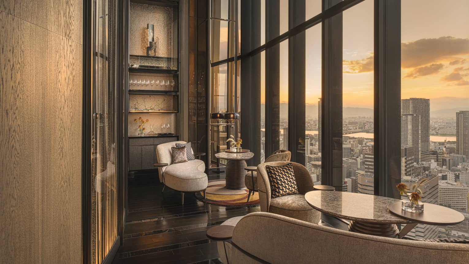 Four Seasons Hotel Osaka bar seating set next to wall of windows overlooking city