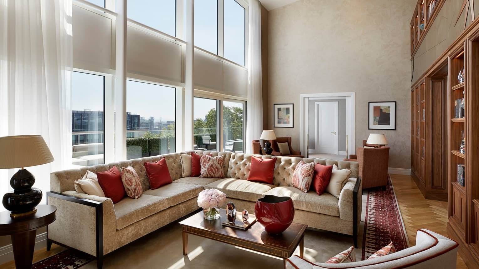 Large L-shaped velvet sofa, living room under sunny, two-storey floor-to-ceiling window