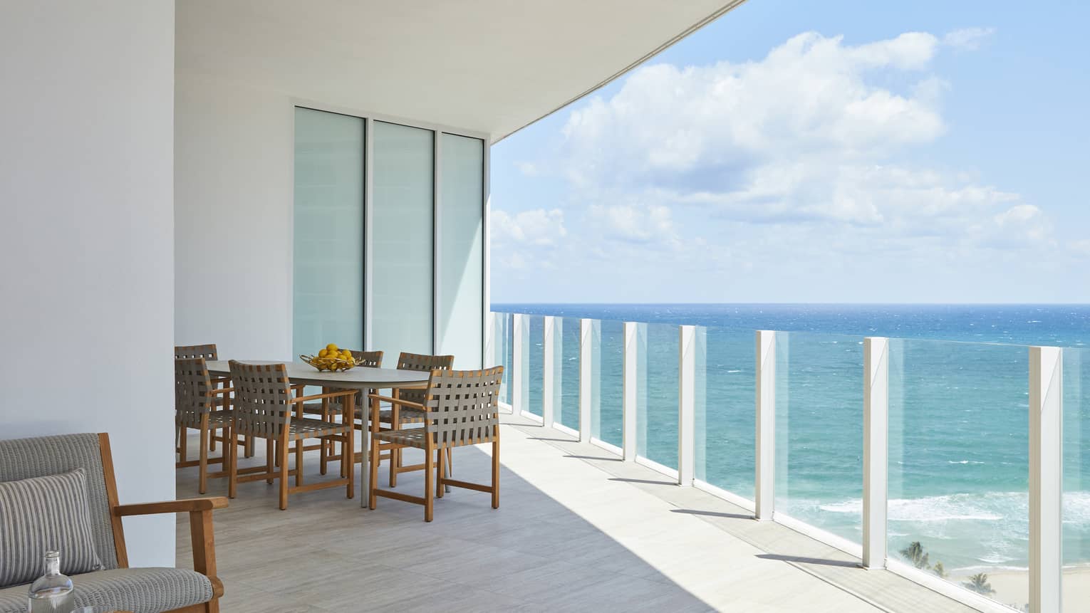 Glass railing balcony with dining table, ocean view
