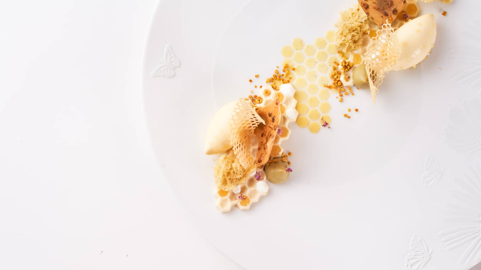 A dessert of honeycomb and chocolate on a white plate.