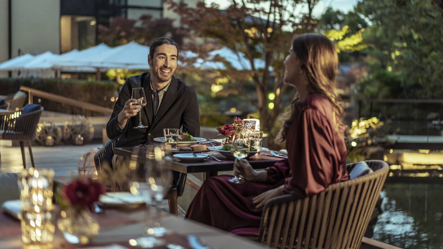 Couple enjoys a romantic meal at dusk on Brasserie?s outdoor terrace with views of Shakusui-en pond garden