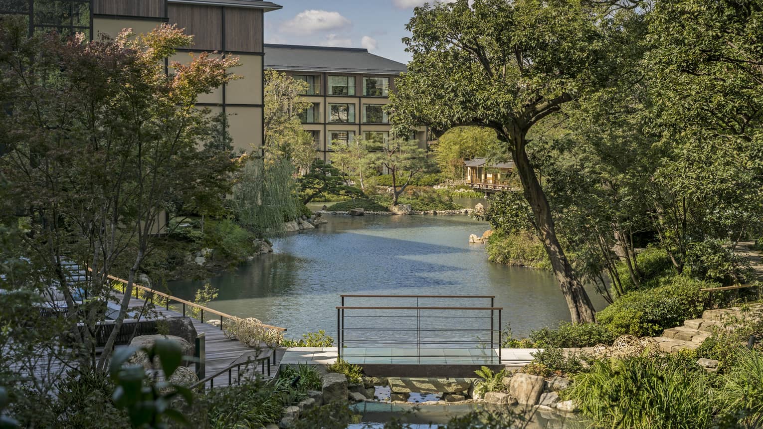 Trees, Shakusuien garden around pond under Four Seasons Hotel Kyoto building