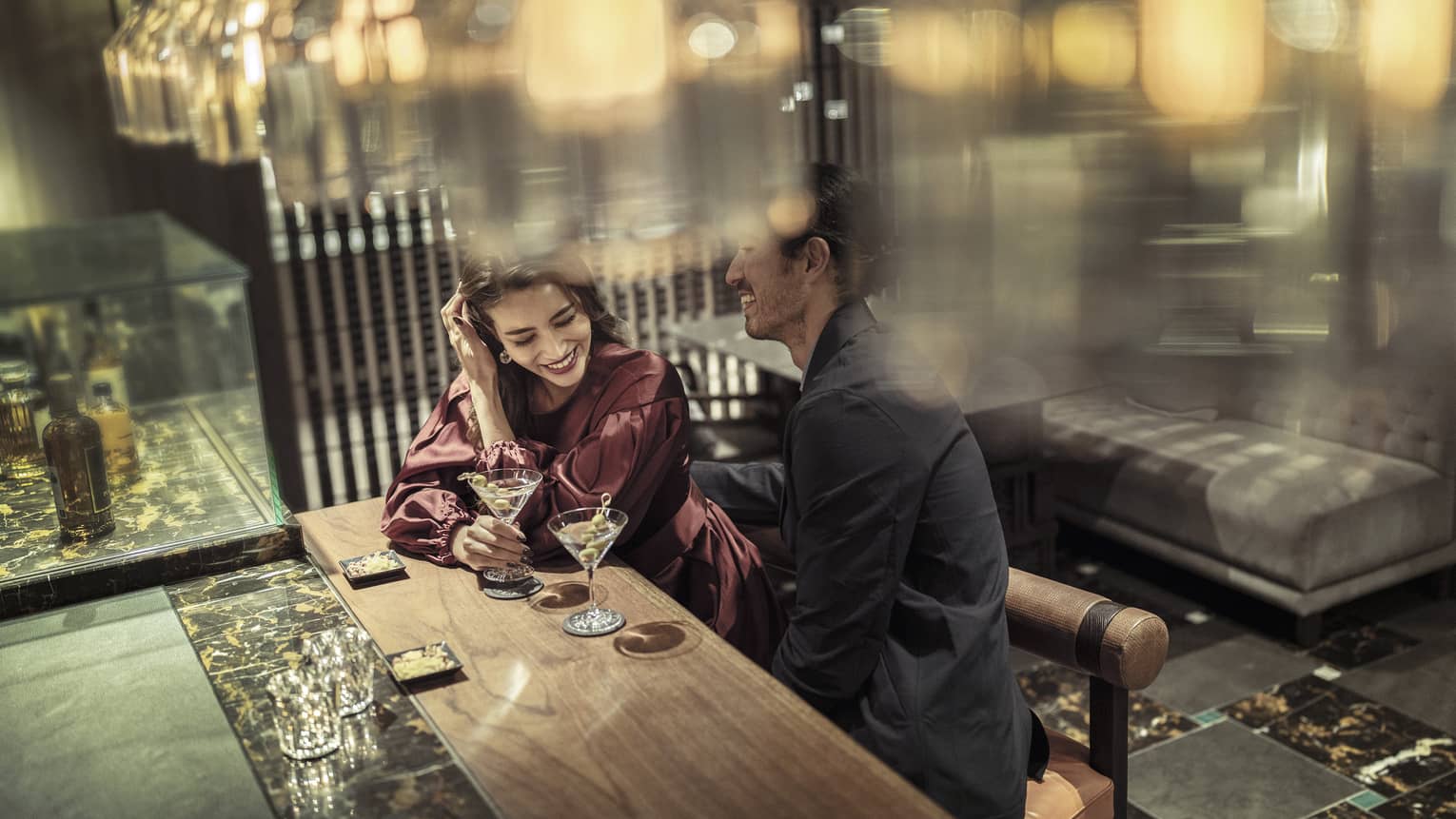 Laughing couple enjoys martinis at The Lounge 
