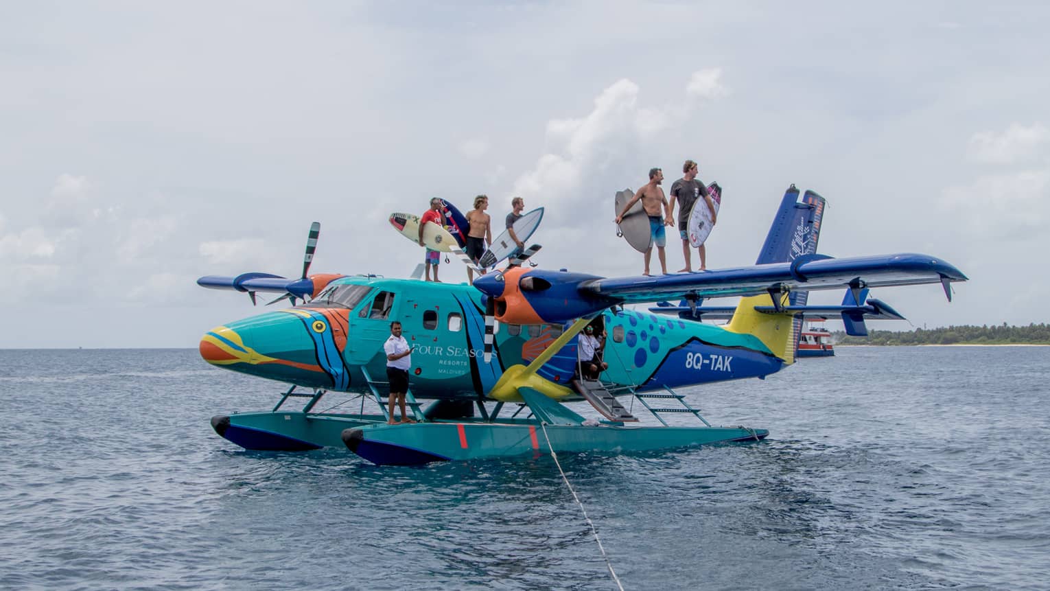 Surfers pose for camera aboard the colourful sea plane the Flying Triggerfish