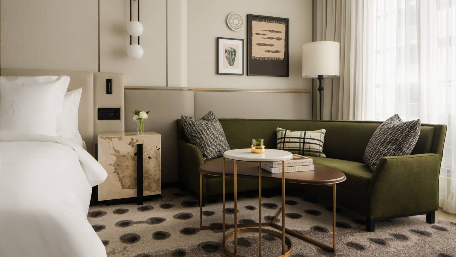 Guest room with dark green corner sofa at Four Seasons Hotel Toronto