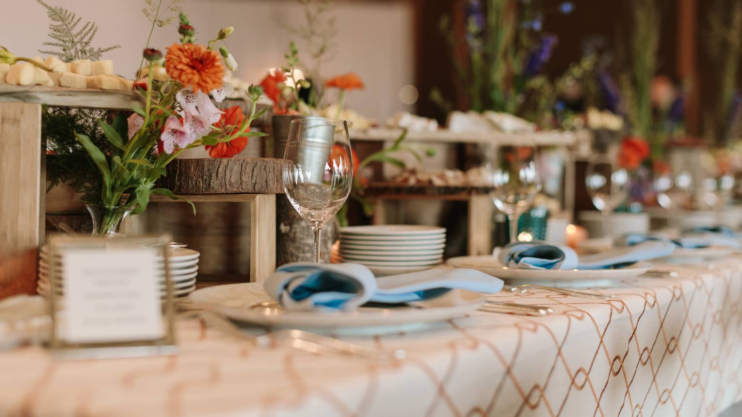 Wedding dining table set with flowers, cheeses on rustic wood platters