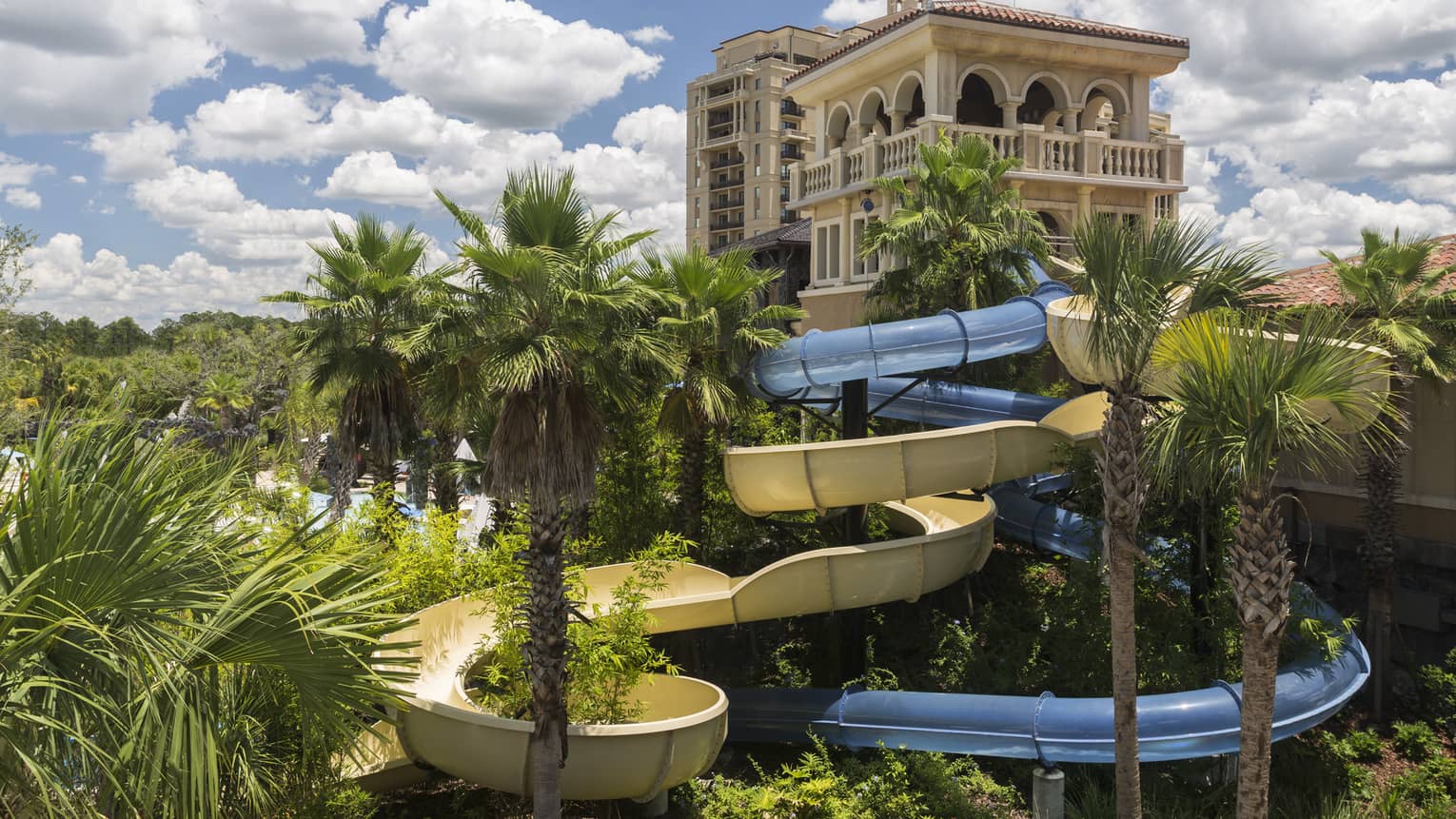Building over winding outdoor water slide, palm trees