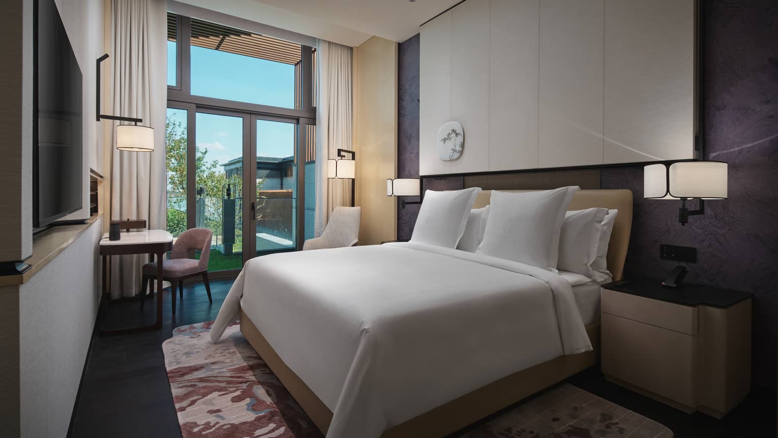 Hotel suite with king bed, desk and garden view at Four Seasons Hotel Suzhou