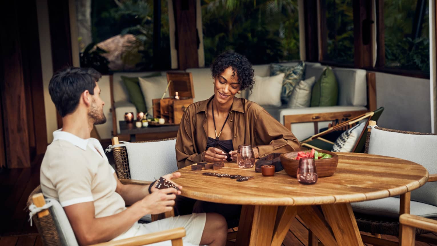 A man and woman sitting at a round table in a luxury tent.